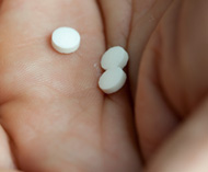 Hand holding round white pills Hand holding round white pills